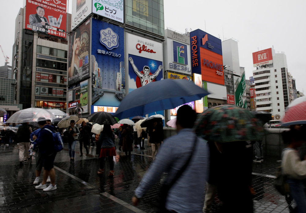 Commuters walk under umbrellas in Osaka, western Japan, October 22, 2017. u00e2u20acu201d Reuters pic