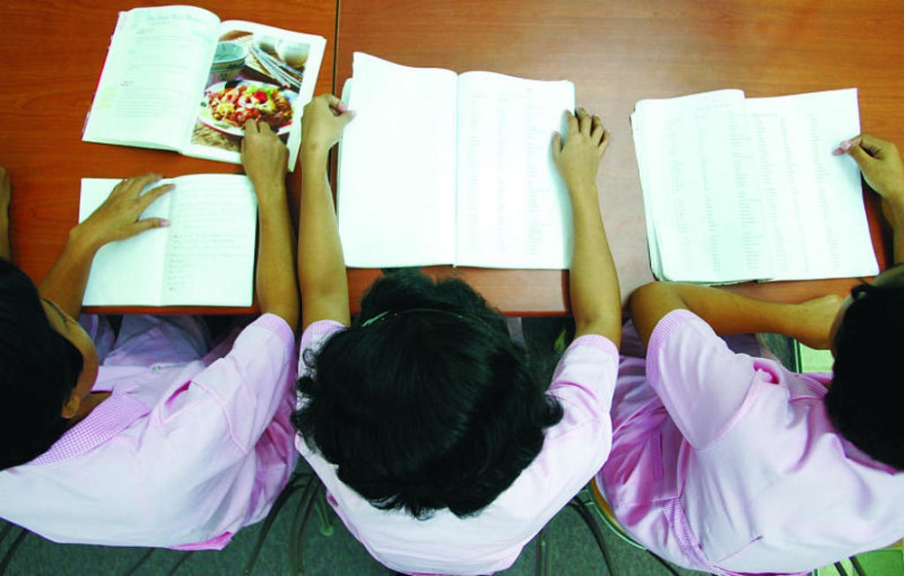 Domestic helpers doing their revision with language and recipe books at an agency. u00e2u20acu201d TODAY pic