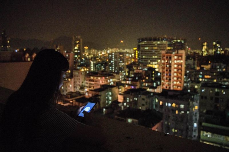 24-year-old Nicole, a pseudonym she chose to protect her identity, looks at her phone while using the popular messaging app WeChat in Hong Kong. u00e2u20acu201d AFP picnn