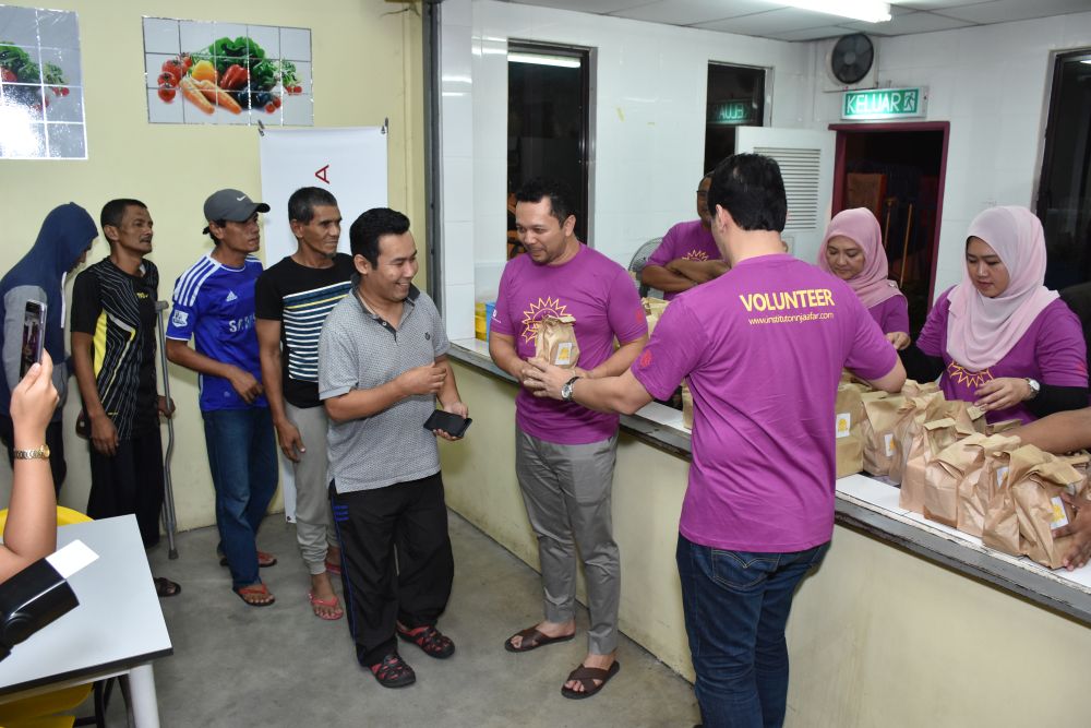 Volunteers from Universiti Kebangsaan Malaysia distribute packs of food to the homeless. u00e2u20acu201d Picture by Azneal Ishak