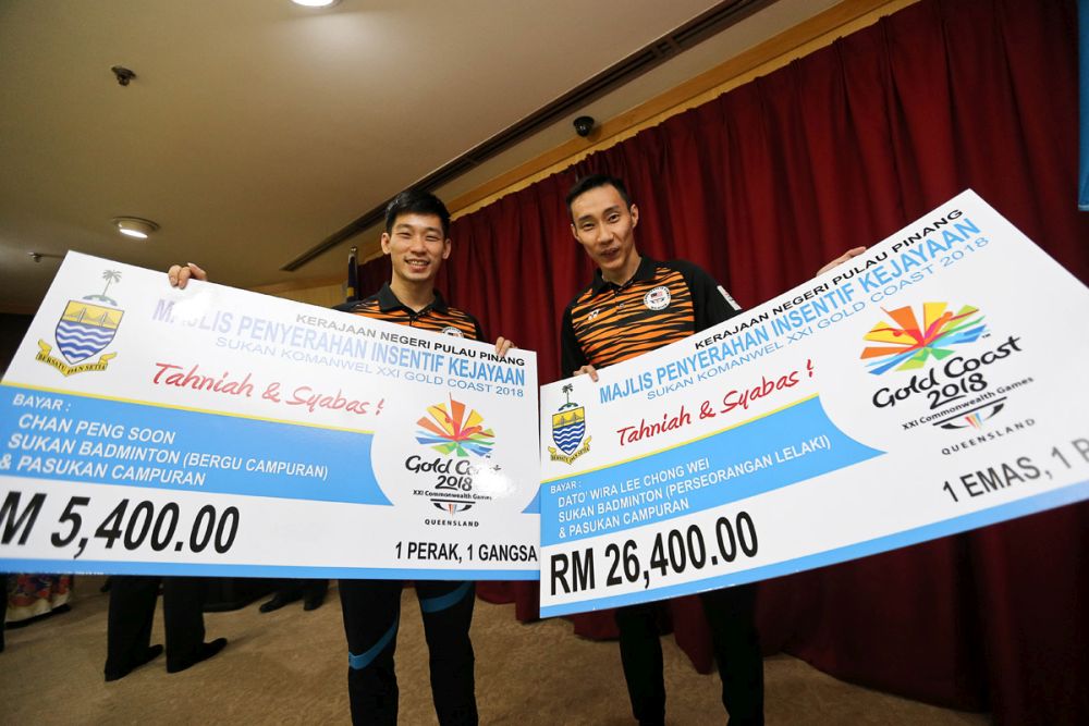 National shuttlers Datuk Lee Chong Wei (right) and Chan Peng Soon pose with their mock checks from the Penang government in Komtar May 31, 2018. u00e2u20acu201d Picture by Sayuti Zainudin