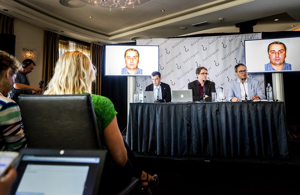 Eliot Higgins (centre) addresses a press conference on findings in research on Malaysia Airlines flight MH17 in Scheveningen, Netherlands, on May 25, 2018, while a picture of Russian army officer Oleg Ivannikov is seen in the background. u00e2u20acu201d AFP pic