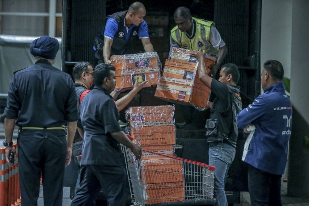 Investigators lift sealed boxes believed to contain luxury designer bags onto a Black Maria outside Pavilion Residences in Kuala Lumpur May 18, 2018. u00e2u20acu201d Picture by Hari Anggara  