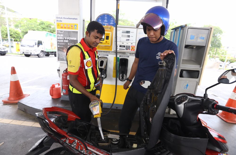 A pump attendant refuels a bike at the Bandar Puteri Puchong Shell petrol station on May 15, 2018. u00e2u20acu201d Picture by Zuraneeza Zulkifli