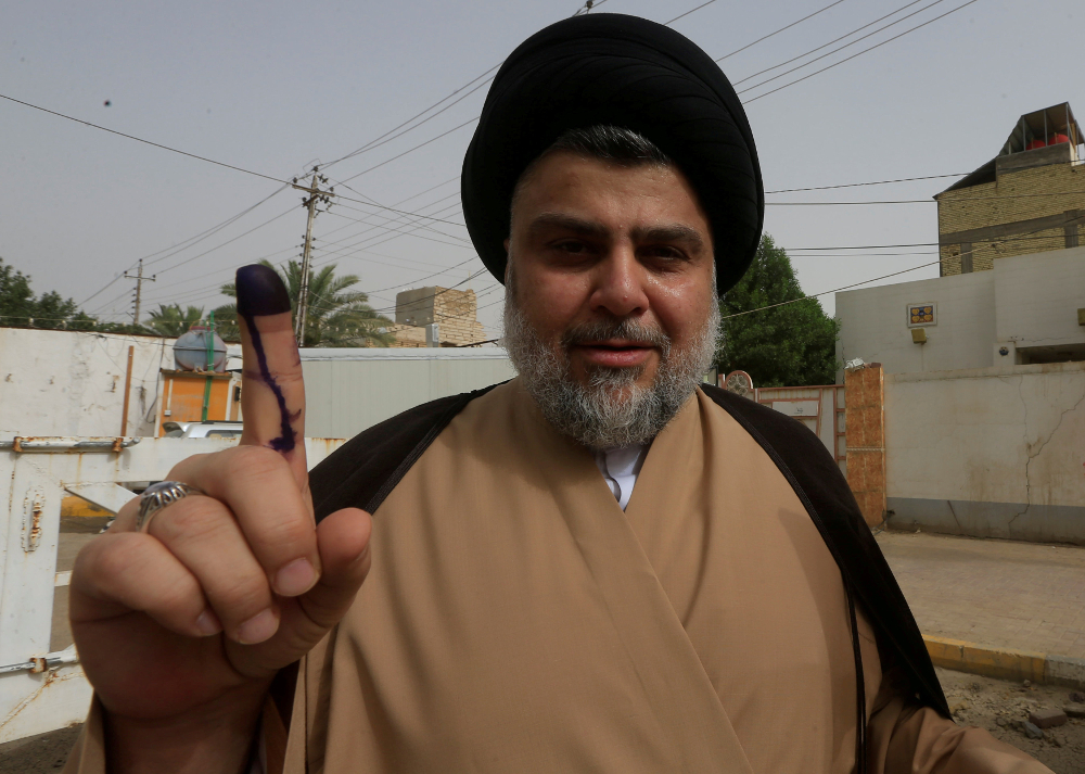 Iraqi Shiah cleric Moqtada al-Sadr shows his ink-stained finger after casting his vote at a polling station during the parliamentary election in Najaf May 12, 2018. u00e2u20acu201d Reuters pic