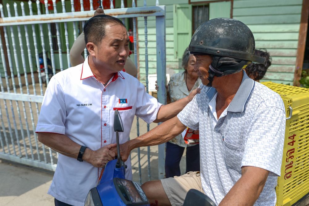 Ng is seen here greeting a Sekinchan voter during his walkabout in Kampung Baru Site B, Sekinchan.