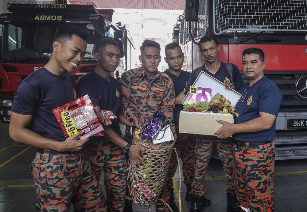 Firemen from Balai Bomba Sri Hartamas receive chocolates from Siti Kasim in Kuala Lumpur May 26, 2018. u00e2u20acu2022 Picture by Firdaus Latif