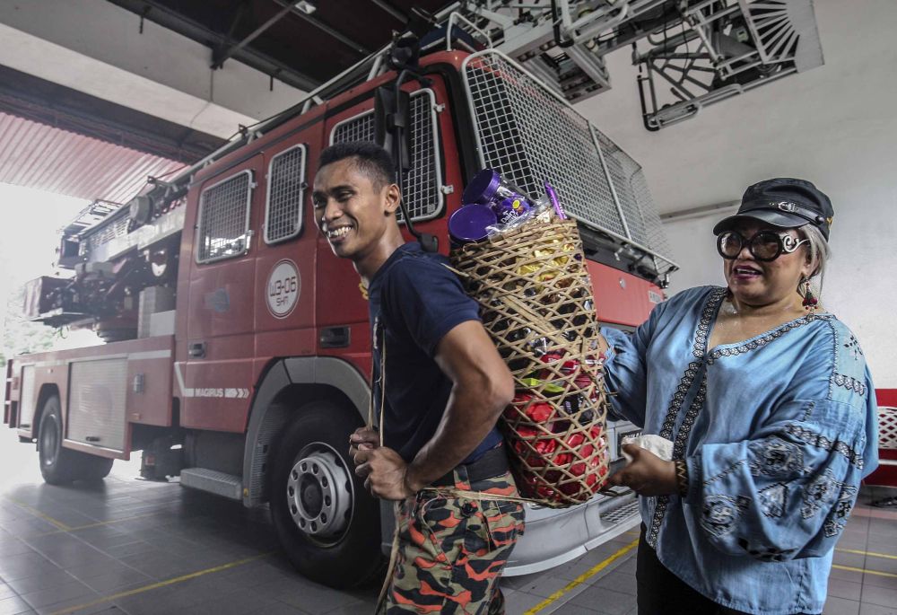 A fire and rescue personnel from the Sri Hartamas Fire and Rescue station receives chocolates from lawyer and activist Siti Kasim, May 26, 2018.