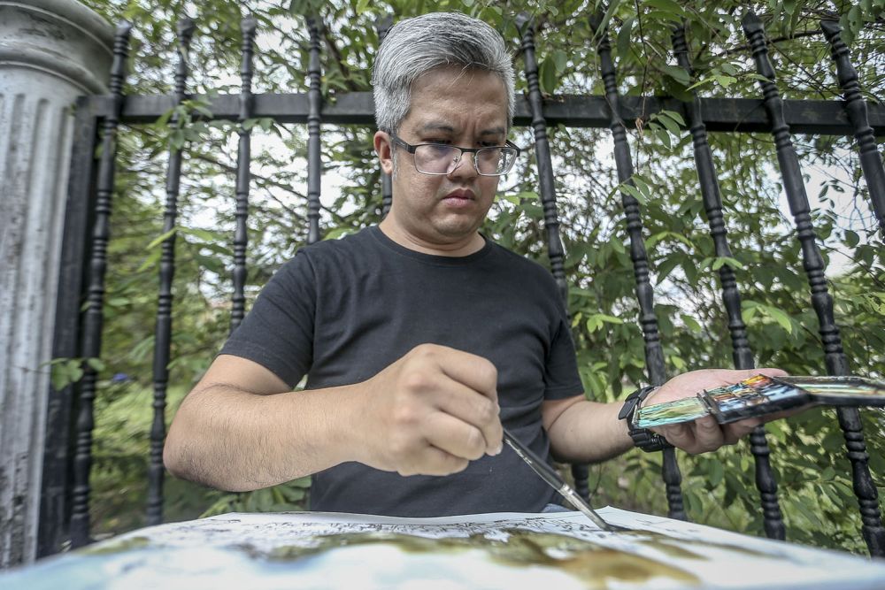 Tan Poh Chuan, 45, works on a watercolour painting outside former prime minister Datuk Seri Najib's residence in Taman Duta May 23, 2018. u00e2u20acu201d Picture by Hari Anggara