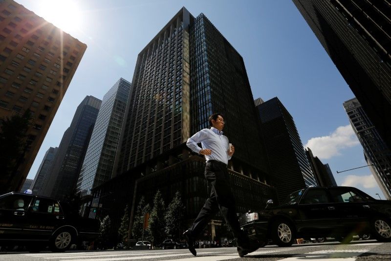 A man runs on a crosswalk at a business district in central Tokyo. u00e2u20acu2022 Reuters pic