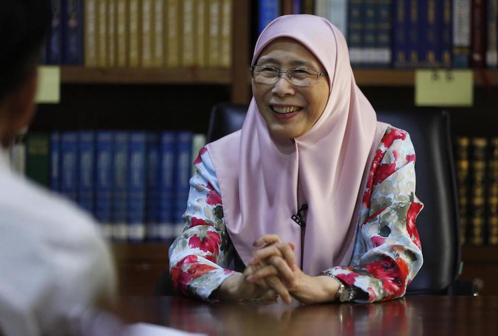 Dressed in a pink headscarf and traditional baju kurung with a floral print, Dr Wan Azizah holds court in her library, which is filled with a vast collection of titles. u00e2u20acu201d TODAY pic