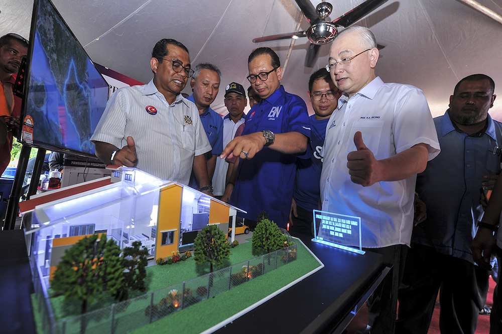 Datuk Khaled Nordin, Datuk Samsolbari Jamali and Datuk Seri Wee Ka Siong look at the models of houses during the ground-breaking for affordable houses in Yong Peng May 7, 2018. u00e2u20acu201d Picture by Shafwan Zaidon