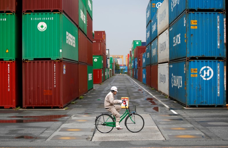 A worker rides a bicycle in a container area at a port in Tokyo April 21, 2014. u00e2u20acu201d Reuters pic