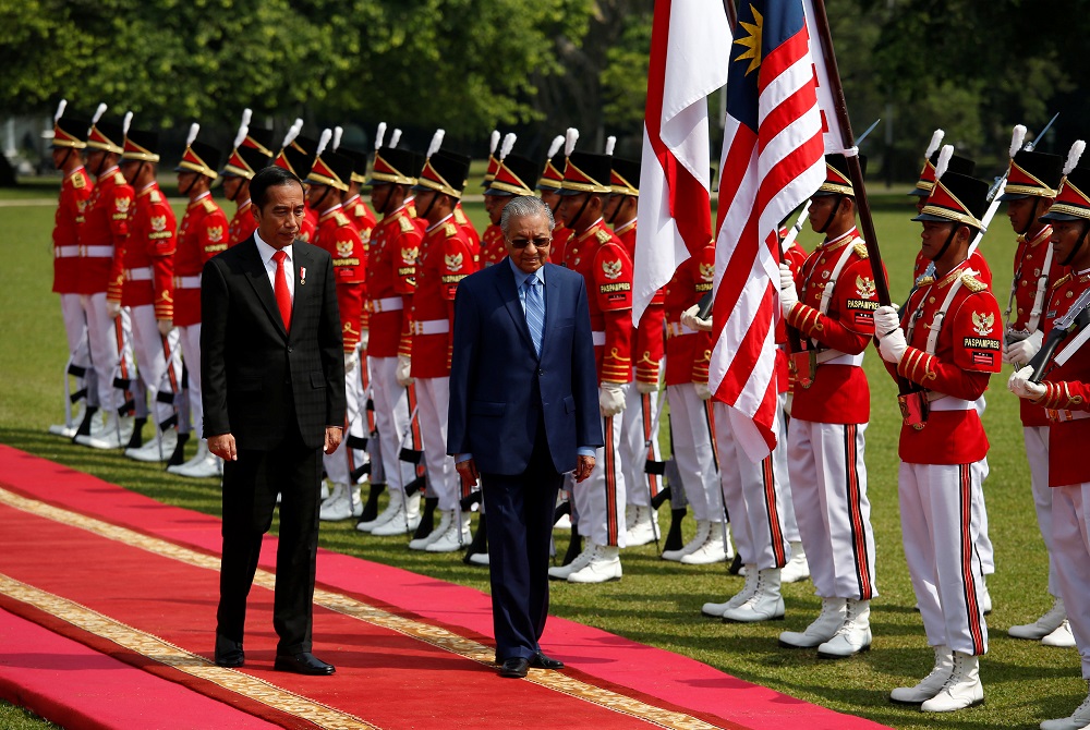 Indonesian President Joko Widodo and  Prime Minister Tun Dr Mahathir Mohamad walk past an honour guard during a welcoming ceremony at the presidential palace in Bogor, south of Jakarta June 29, 2018. u00e2u20acu201d Reuters pic