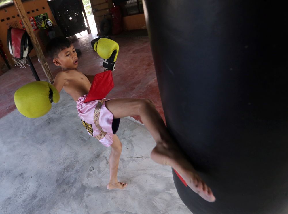 Iskandar Hazriq Mohd Ezry Azamin, 12, kicking a punching bag at his home in Taiping.  u00e2u20acu201d Picture by Farhan Najib