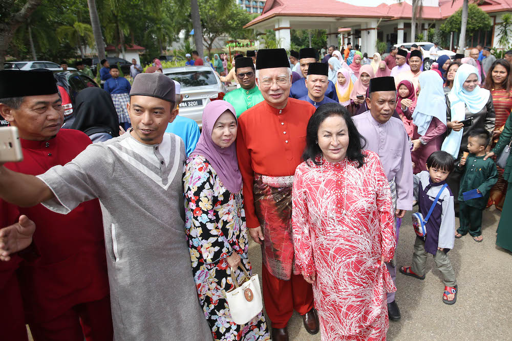 People take selfies with Datuk Seri Najib Razak and Datin Seri Rosmah Mansor at their Aidilfitri open house in Pekan June 15, 2018. — Picture by Azinuddin Ghazali