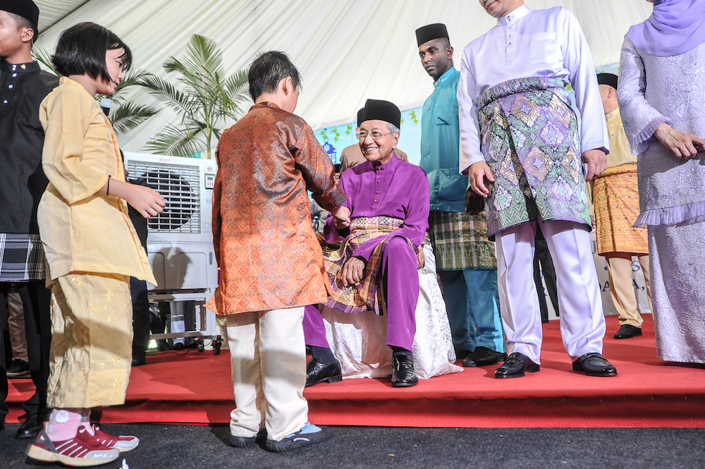 Tun Dr Mahathir Mohamad greets a boy during the prime ministeru00e2u20acu2122s Aidilfitri open house in Putrajaya June 15, 2018. u00e2u20acu201d Picture by Shafwan Zaidon