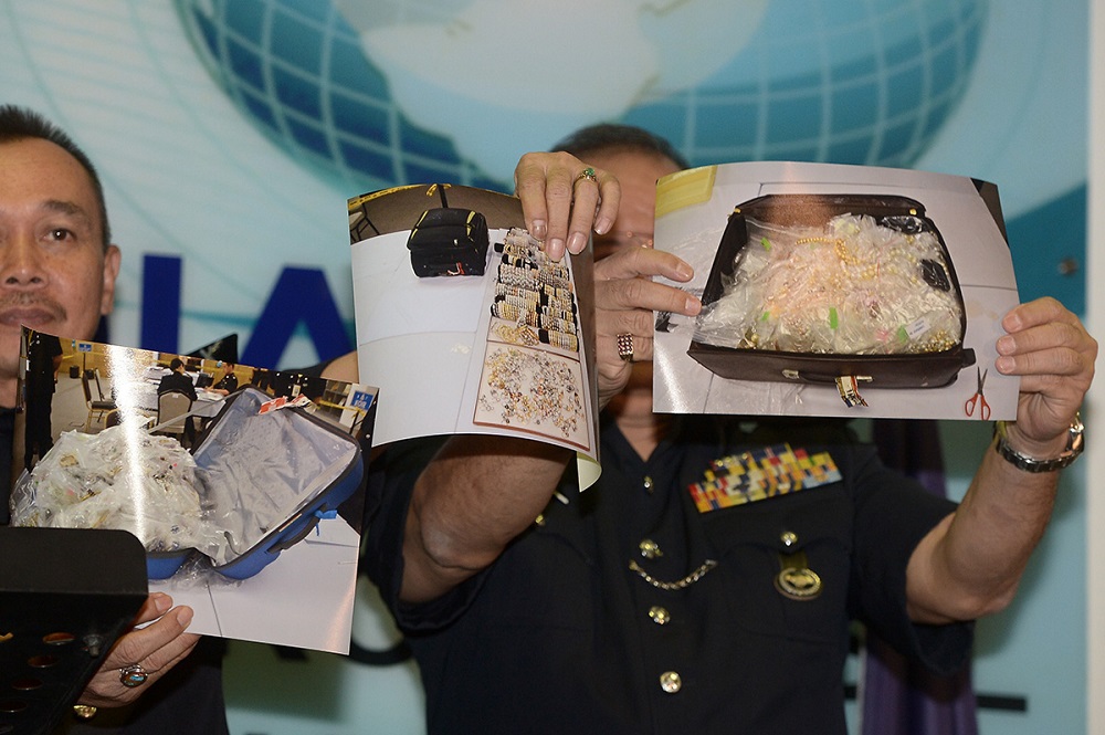 Police officers display photos of some of the valuables seized in the raids conducted on Datuk Seri Najib Razaku00e2u20acu2122s properties, in Kuala Lumpur June 27, 2018. u00e2u20acu201d Picture by Mukhriz Hazim