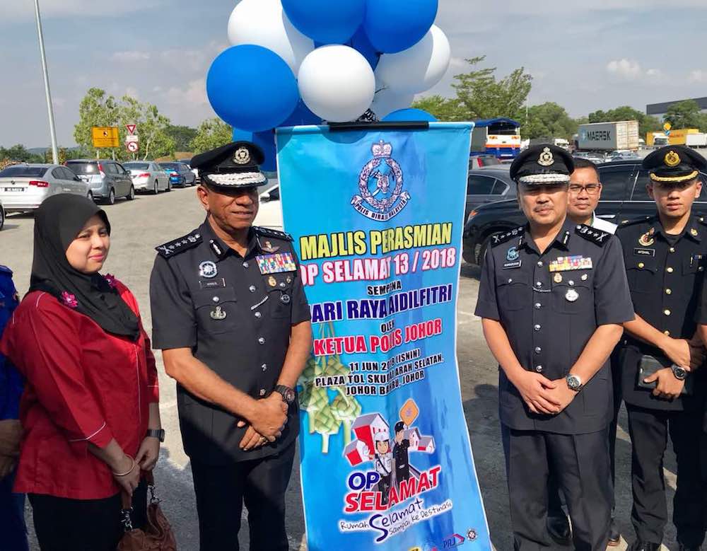 Johor police chief Datuk Mohd Khalil Kader Mohd (2nd left) poses with the Ops Selamat 2018 road safety campaign banner during the event’s state level launch at the Skudai toll plaza (southbound) this afternoon. — Picture by Ben Tan