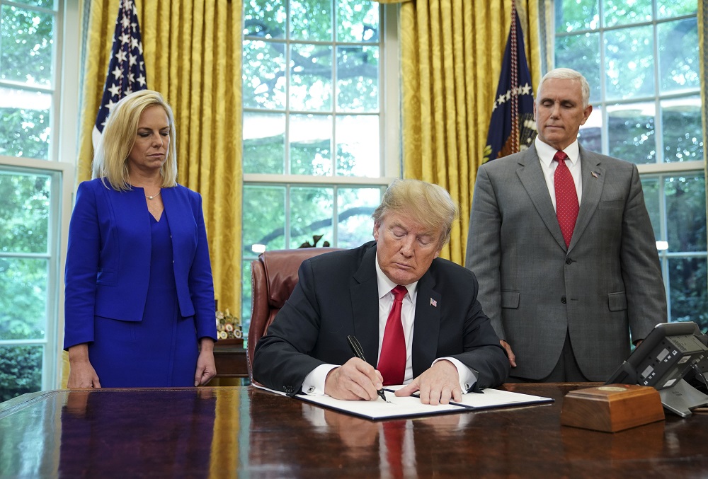 Watched by Homeland Security Secretary Kirstjen Nielsen and Vice President Mike Pence, US President Donald Trump signs an executive order on immigration in the Oval Office of the White House on June 20, 2018 in Washington, DC. u00e2u20acu201d AFP pic