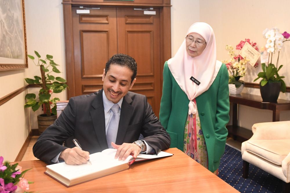 Qatari ambassador Essa Mohamed Al Mannai signs a guestbook next to Dr Wan Azizah prior to their private meeting in Putrajaya June 4, 2018. u00e2u20acu201d Picture courtesy of the DPMu00e2u20acu2122s office