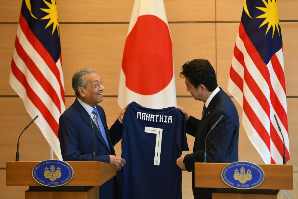 Tun Dr Mahathir Mohamad receives a Japanese national football jersey as a present from his Japanese counterpart Shinzo Abe during their joint press remarks at Abe's official residence in Tokyo, June 12, 2018. u00e2u20acu2022 Reuters pic