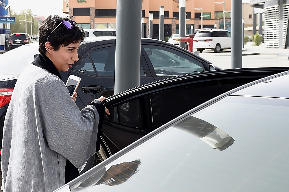  A Saudi female customer gets into the car of Reem Farahat, a female employee of Careem, a chauffeur car booking service, in the Saudi capital of Riyadh, on June 24, 2018. 
