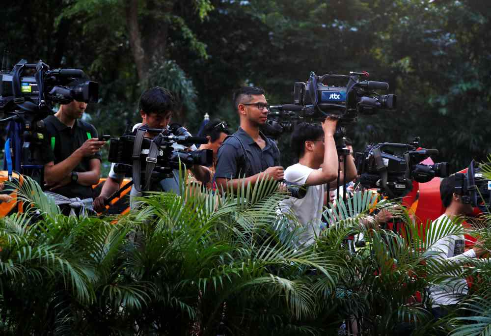 Members of the media stand behind potted plants as they wait outside St Regis Hotel in Singapore June 9, 2018. u00e2u20acu2022 Reuters pic