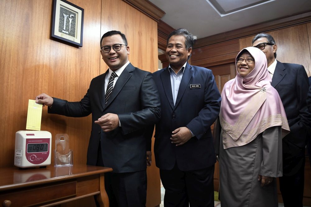 New Selangor MB Amirudin Shari (left) clocks in at work earlier today. u00e2u20acu201d Bernama pic