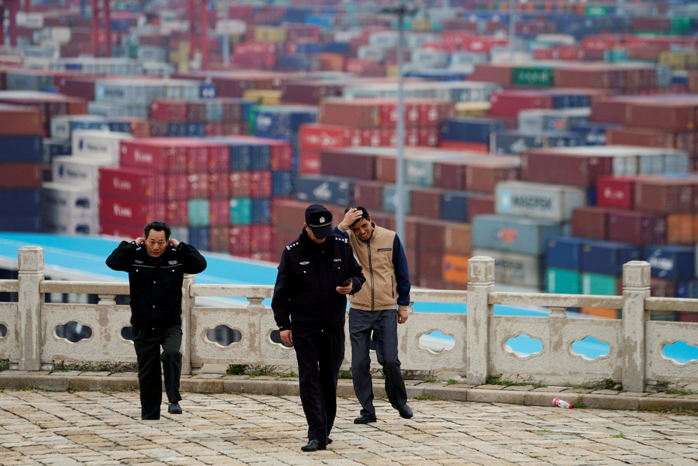 Security guards walk in front of containers at the Yangshan Deep Water Port in Shanghai April 24, 2018. u00e2u20acu201d Reuters pic