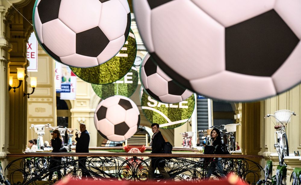 People walk on a bridge under football-themed decorations at the GUM department store in downtown Moscow on June 7, 2018. u00e2u20acu201d AFP pic