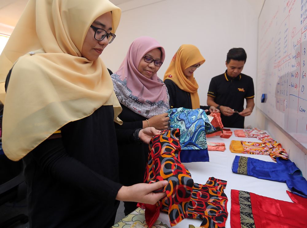 Faizulniza (second from left) said she has had to turn down orders due to the overwhelming response to Geli-Geli Kucing’s ‘baju raya’. ― Picture by Farhan Najib