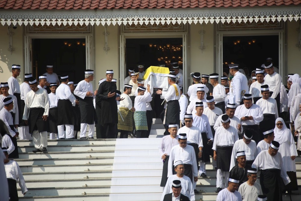Remains of Enche’ Besar Hajah Khalsom Abdullah being brought out of the grand steps of the Istana Besar’s main entrance before the funeral procession June 6, 2018. 