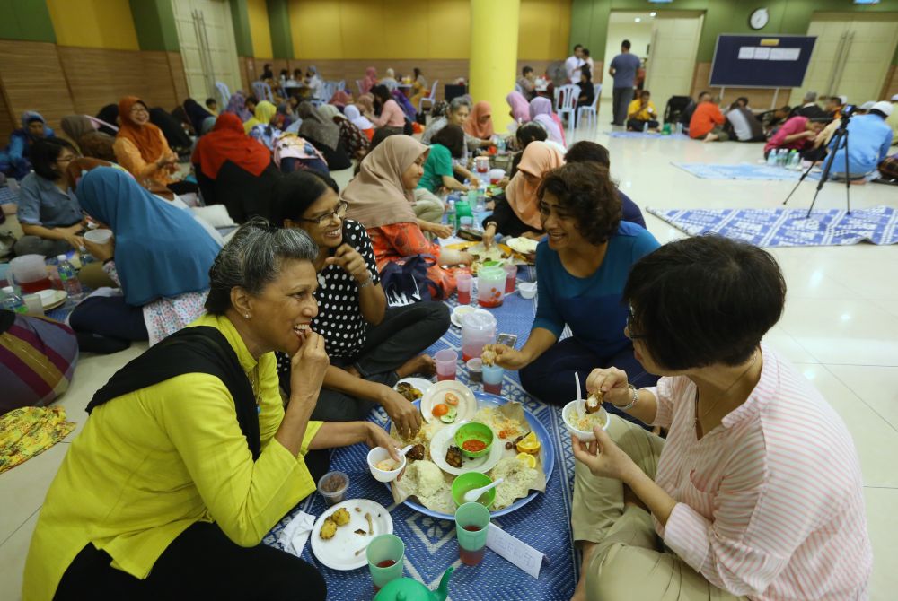 Participants share their meals in a huge tray and eat together right after the Maghrib azan. u00e2u20acu201d Picture by Zuraneeza Zulkifli