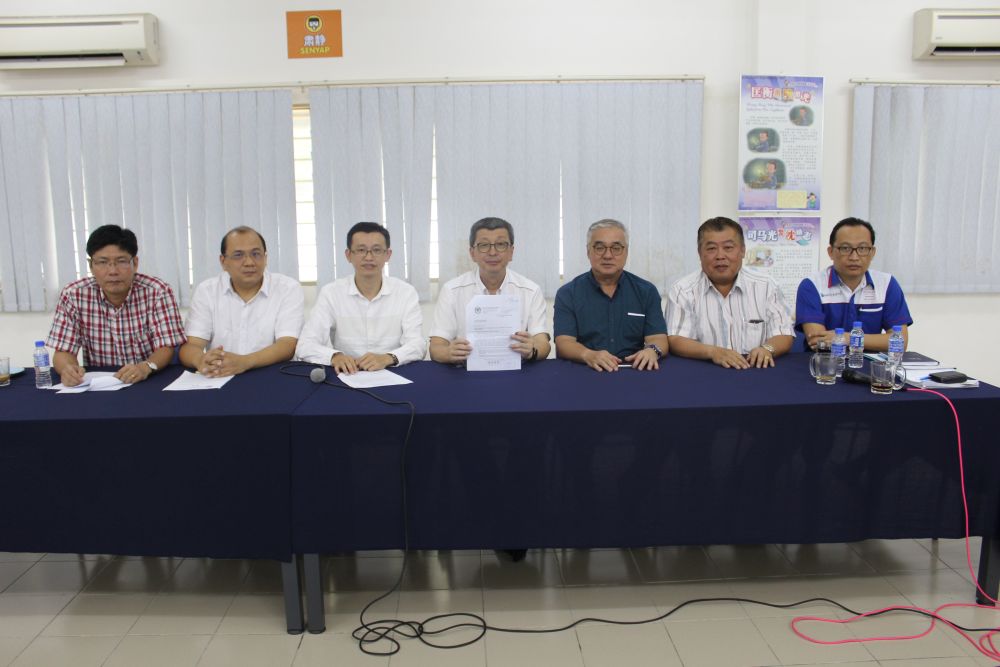 Lim (centre) holds up a statement expressing disappointment over the directive. u00e2u20acu201d Picture courtesy of SJK (C) Tun Tan Siew Sin 