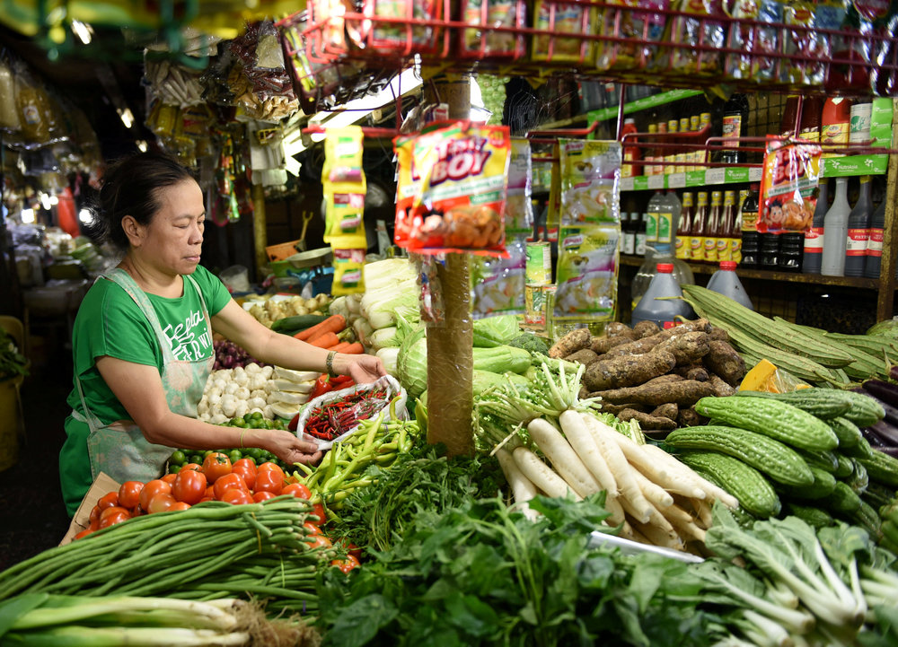 A woman arranges vegetables in a market stall in Edsa Kamias in metro Manila May 23, 2018. u00e2u20acu201d Reuters pic