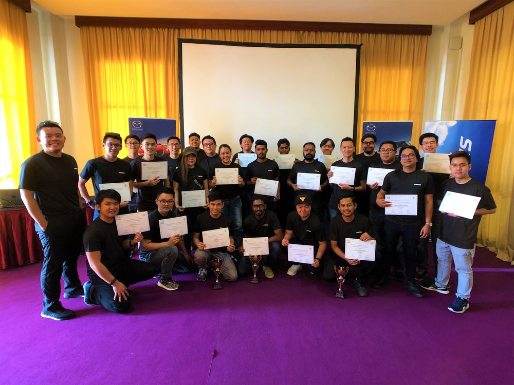 Happy Mazda owners with their certificates of accomplishment.