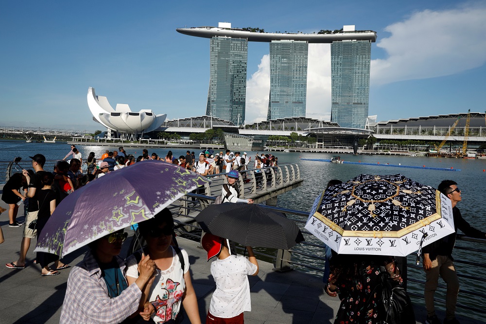 Tourists shield themselves with umbrellas from the sun in Singapore May 24, 2018. u00e2u20acu201d Reuters pic