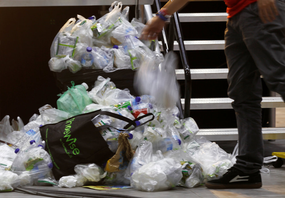 A man tosses a plastic bag over a pile of trash after an event in Singapore April 28, 2018. u00e2u20acu201d Reuters picn