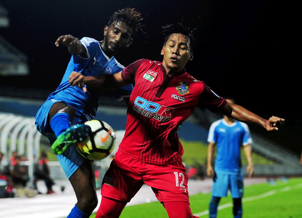 Penang captain K. Thivandaran (left) in a tussle for possession with Police player Mohd Kamal Rodiarjat Md Ali in the Premier League match at Batu Kawan State Stadium June 25, 2018. u00e2u20acu201d Bernama pic