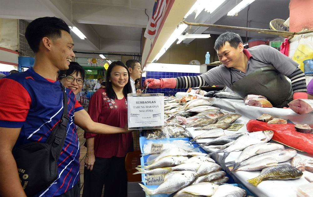 A trader at the Taman Tun Dr Ismail market donates to Tabung Harapan Malaysia June 12, 2018. u00e2u20acu201d Picture by Ham Abu Bakar