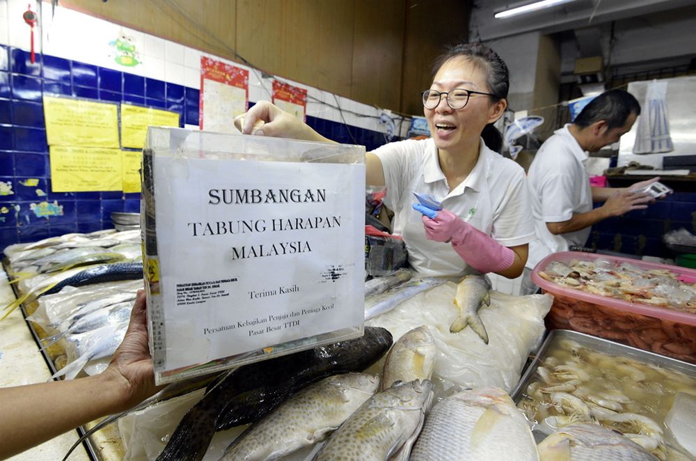 A trader at the Taman Tun Dr Ismail market donates to Tabung Harapan Malaysia June 12, 2018. — Picture by Ham Abu Bakar