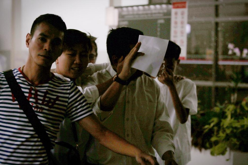 Umar Hassan, police officer who pleaded guilty to being a member of two secret societies, covers his face as he leaves the state courts on June 20, 2018. u00e2u20acu201d Jason Quah/TODAY pic