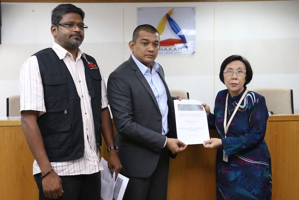 (From left) Suaram Executive Director Sevan Doraisamy and Datuk Seri Sanjeevan Ramakrishnan handing over the memo to Suhakam Commissioner Datuk Lok Yim Pheng, July 16, 2018. u00e2u20acu201d Picture by Zuraneeza Zulkifli