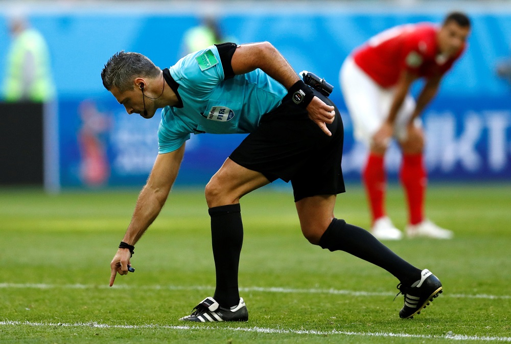 Referee Damir Skomina points to a spot outside the penalty area indicating a free kick after he overturned a penalty decision following a VAR review at Saint Petersburg July 3, 2018. 