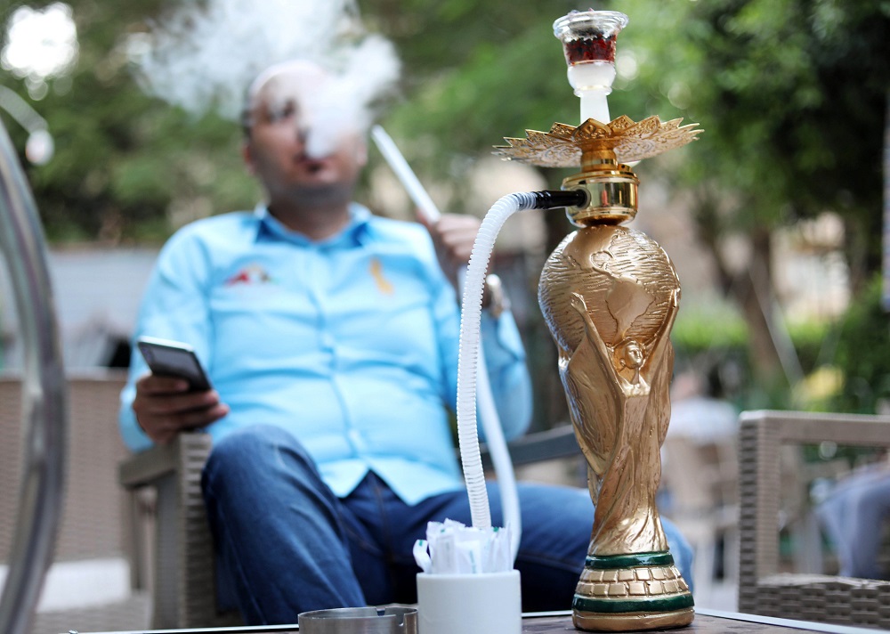 A customer smokes a shisha shaped as World Cup trophy replica at a cafe in Cairo July 4, 2018. u00e2u20acu201d Reuters pic