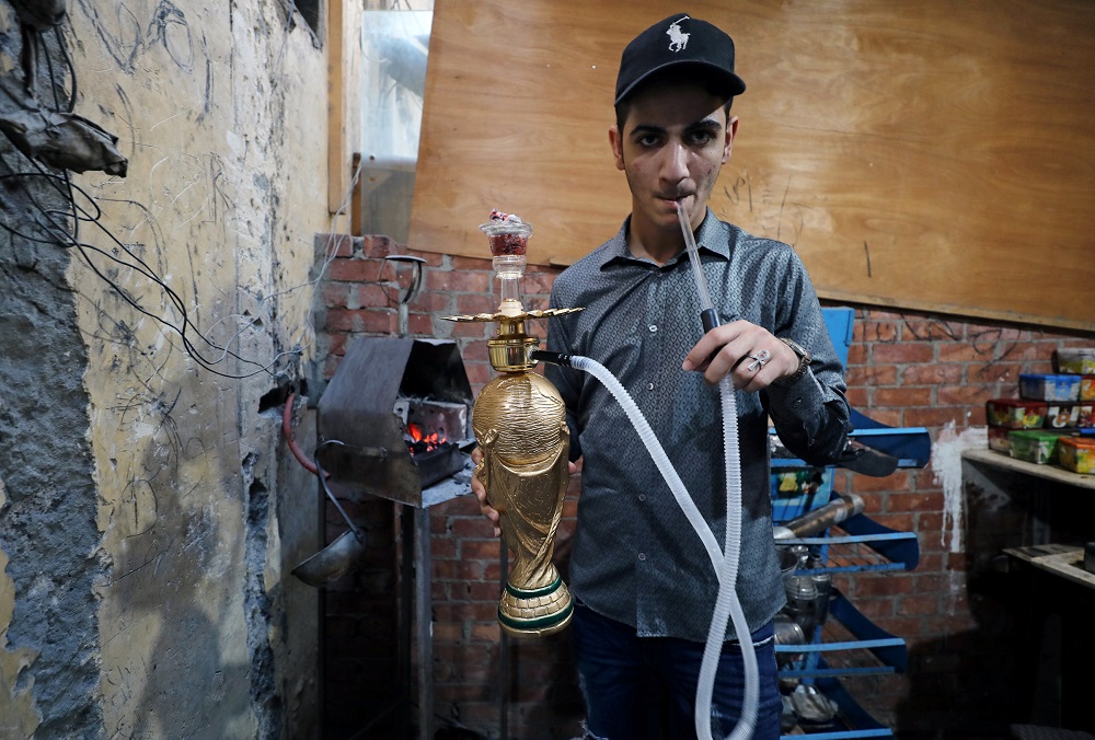 A cafe worker prepares and smokes a shisha shaped as World Cup trophy replica at a cafe in Cairo July 4, 2018. u00e2u20acu201d Reuters pic