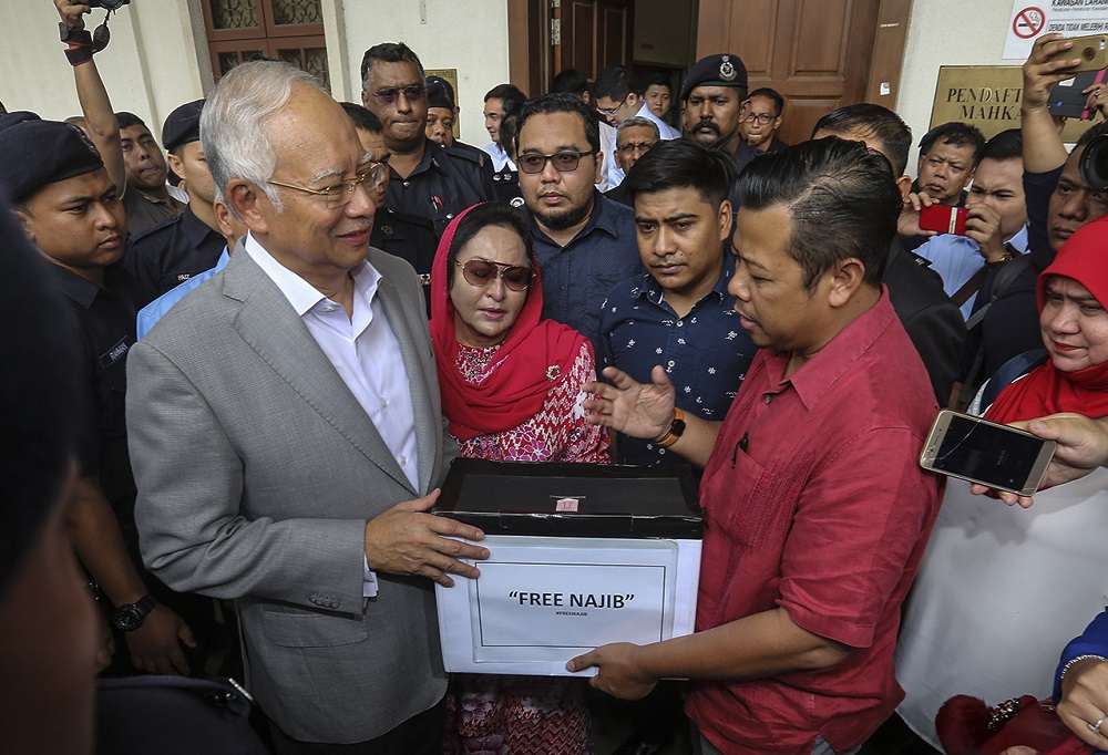 Former prime minister Datuk Seri Najib Razak receives the donations collected from the u00e2u20acu02dcFree Najibu00e2u20acu2122 campaign from Datuk Razlan Rafii (right) at the Kuala Lumpur Courts Complex July 9, 2018. u00e2u20acu201d Picture by Azneal Ishak