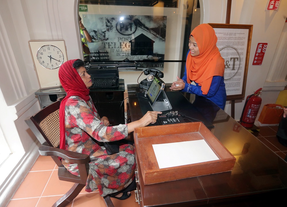 A museum staff (right) briefs a visitor about one of the items on display in the Telegraph Museum in Taiping. 
