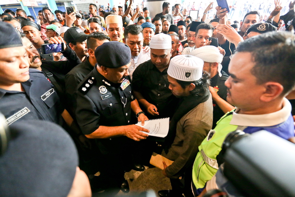 Ex-PPIM member Yusof Azmi (right) speaks to North-east OCPD Anuar Omar (left) before presenting a memorandum during a protest at Komtar in George Town July 27, 2018. — Picture by Sayuti Zainudin